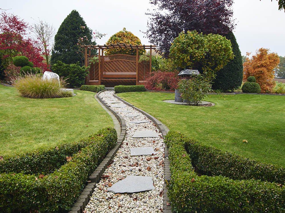 Gartengestaltung mit Gartenweg und Bepflanzung in Vlotho Gepflegte Gartenanlage mit geschwungenem Kiesweg, Rasen, Hecken und abwechslungsreicher Bepflanzung