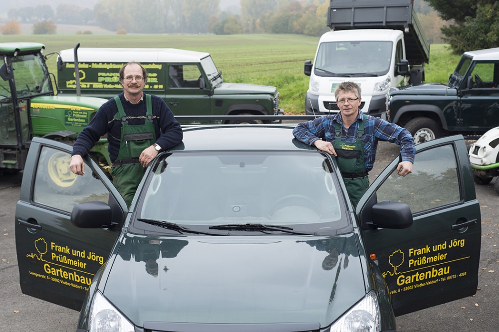 Frank und Jörg Prüßmeier GbR – Gartenbau in Vlotho Zwei Mitarbeiter der Frank und Jörg Prüßmeier GbR vor einem Firmenfahrzeug für Gartenbau in Vlotho