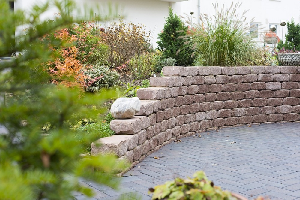 Gartengestaltung mit Natursteinmauer in Vlotho Gestaltete Gartenanlage mit Natursteinmauer, Pflasterfläche und abwechslungsreicher Bepflanzung