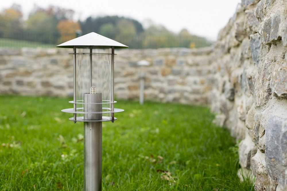 Gartenbeleuchtung und Natursteinmauer in Vlotho Moderne Gartenleuchte vor einer Natursteinmauer auf gepflegter Rasenfläche