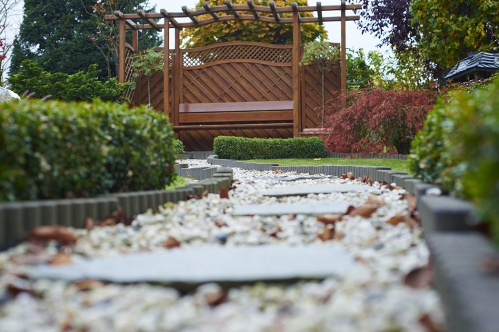 Gartenweg mit Kies und Trittplatten in Vlotho Geschwungener Kiesweg mit Trittplatten, niedrigen Hecken und bepflanzter Gartenanlage