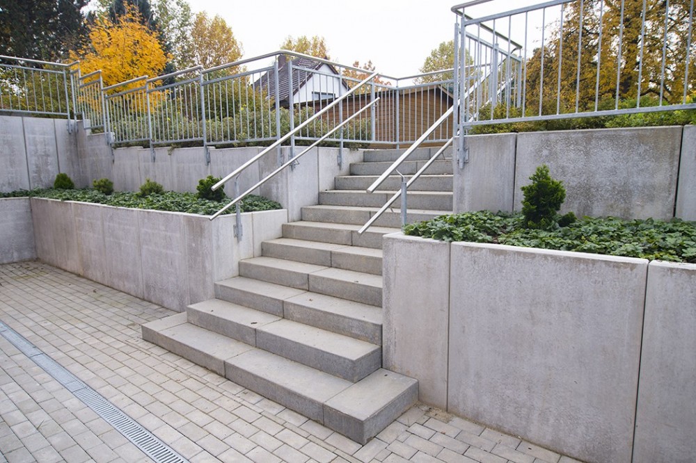Gerade Betontreppe mit Metallgel&auml;nder zwischen gestuften Betonst&uuml;tzw&auml;nden